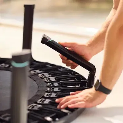 Hands folding a leg of the BERG rebounder flat against the frame